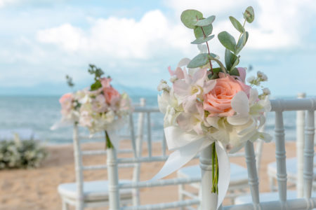Cute pink and white flowers on chiavari chairs at outdoor wedding ceremony.