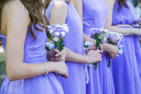 Bridesmaid,Girls,In,Purple,Dresses,Hold,Bouquets,At,An,Outdoor